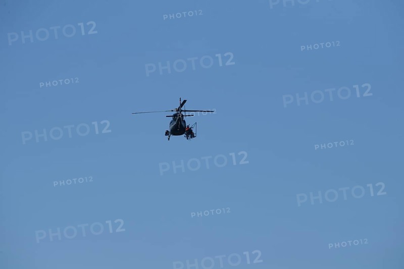 A helicopter can be seen from afar in the blue sky while it is working, Lemförde, Lower Saxony, Germany