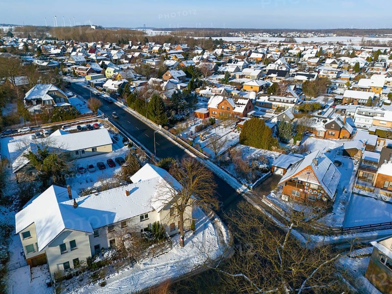 Inhabited area in snow with several houses along a road on a clear day, aerial view, Oelsburg, Ilsede, Peine district, Lower Saxony, Germany