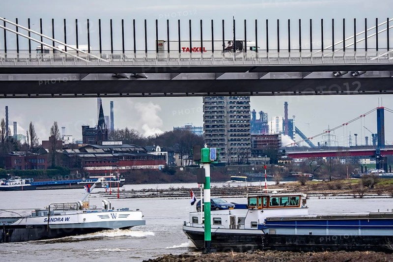 Shipping traffic on the Rhine near Duisburg-Homberg, new A40 motorway, Neuenkamp Rhine bridge, first construction phase, Friedrich-Ebert bridge between Homberg and Ruhrort in the back, industrial setting of the ThyssenKrupp steel plant, North Rhine-Westphalia, Germany