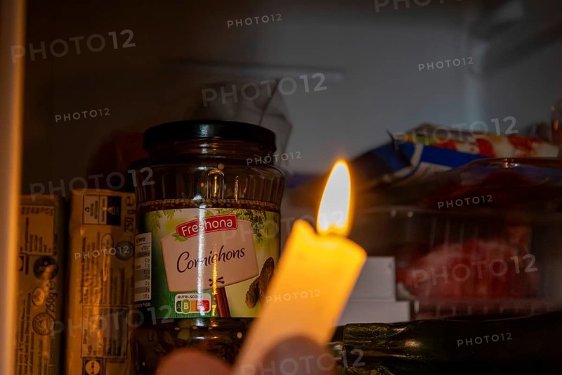 Blackout icon: Illuminating a dark refrigerator with a candle
