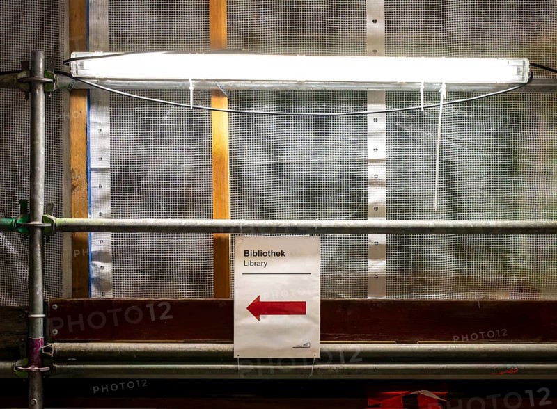 Technical University in Berlin, provisional information sheets and signs at an indoor construction site show the way towards the library, Berlin, Germany