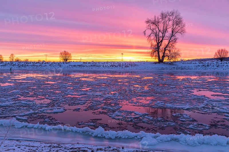 Cold winter morning on the Elbe with floating ice floes, snow and dawn at sunrise, Kötzschenbroda, Radebeul, Saxony, Germany