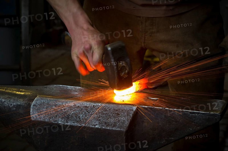Sparks spray, a blacksmith forging, working at the Ehnert forge in Dresden-Bühlau, Saxony, Germany