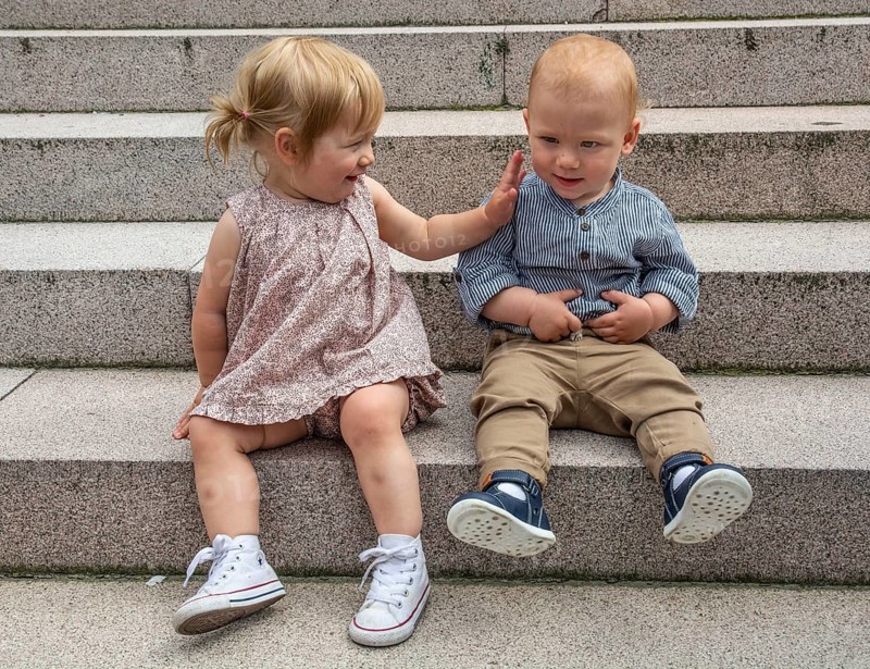 Act of friendship between two blonde children, boy and girl 1.5 years old in Ystad, Skåne County, Sweden, Scandinavia