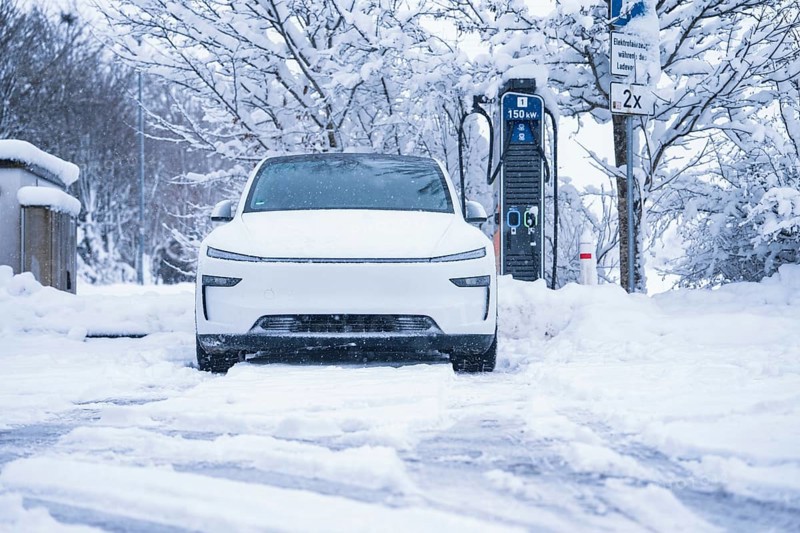 An electric car is parked in a snowy winter landscape next to a charging station, Tesla Model Y electric car, ENBW charging station, Waldachtal, Freudenstadt district, Germany