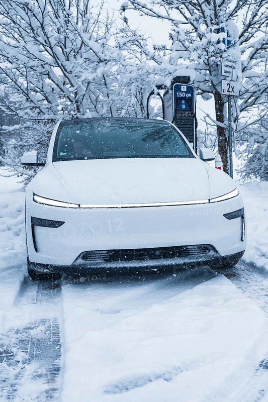 White electric car charging at a charging station in a snowy winter landscape, Tesla Model Y electric car, ENBW charging station, Waldachtal, Freudenstadt district, Germany