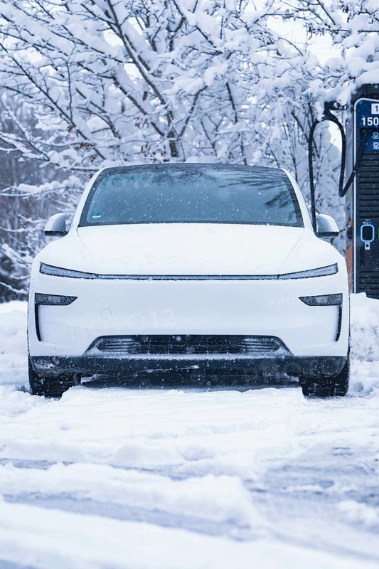 A futuristic white electric car stands in the snow in front of a charging station, Tesla Model Y electric car, ENBW charging station, Waldachtal, Freudenstadt district, Germany