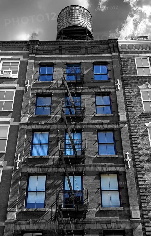 Residential building with fire escapes and wooden water tank on the roof, black and white, Downtown NY, New York City, USA