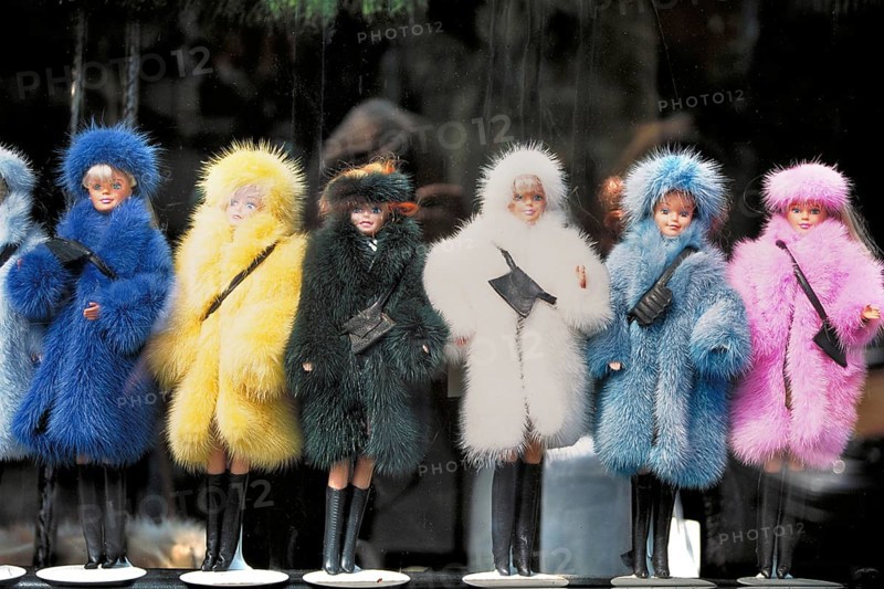 Barbie dolls in different colored fur coats in a shop window, New York City, USA