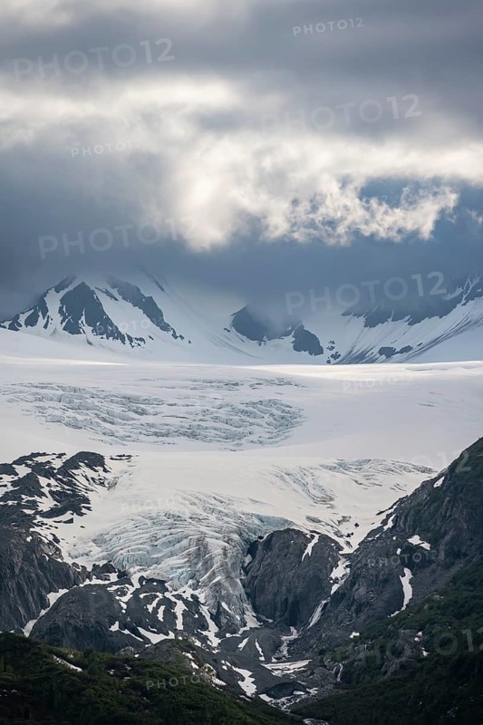 Mountain peak with Worthington Glacier glacier, dramatic cloudy sky, picturesque landscape on Richardson Highway, Chugach Mountains, Alaska, USA