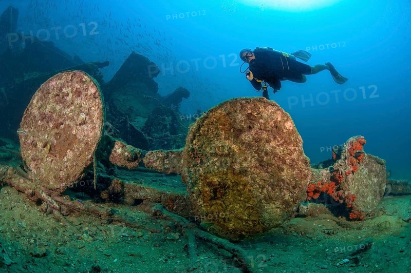 Underwater photo of diver swimming over Boonsung wreck looking at parts of former sunken tin excavator off coast of seaside resort Khao Lak, Andaman Sea, Indian Ocean, Thailand