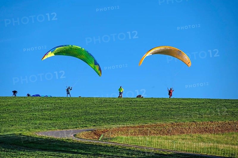 Paragliders on a hillside meadow, blue sky, Tauchersreuth, Middle Franconia, Bavaria, Germany