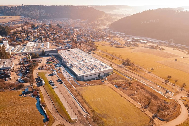 Factory building next to village and snow-covered fields, Glatten, Freudenstadt district, Germany
