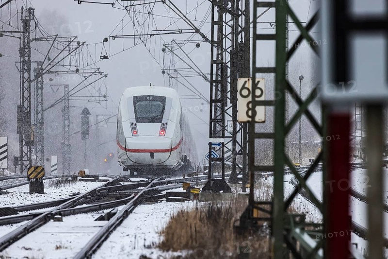 ICE traveling through a winter landscape in snowfall. A train on the line in the Deutsche Bahn Amstetten rail network, Baden-Württemberg, Germany