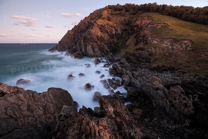 Sunset, Byron Bay, New South Wales, Australia. Waves crashing on rocks at the most easterly point of the mainland during the magical blue hour