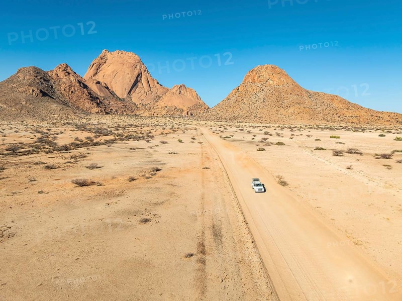 Aerial view, car on sandy road, mountains in the desert, Spitzkoppe summit, Namib desert, Namibia