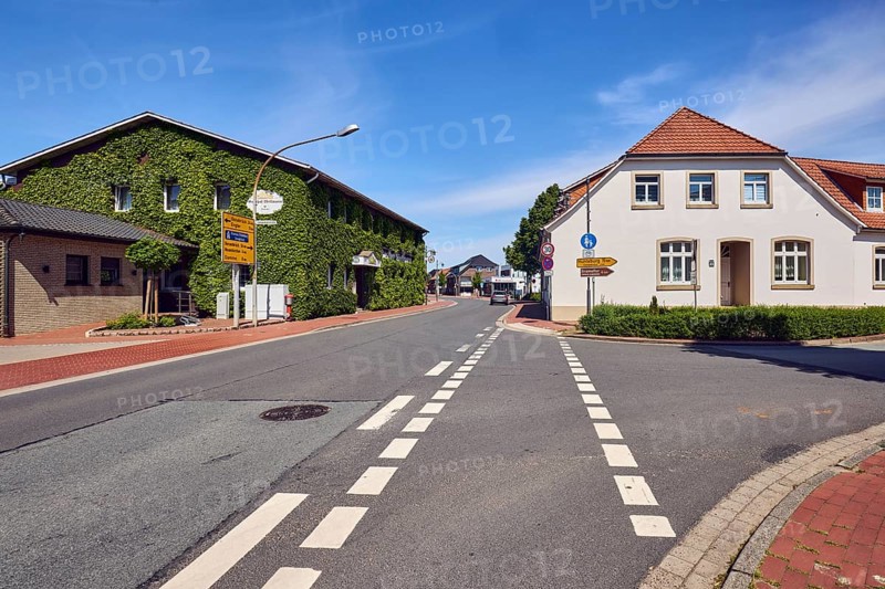 Historic residential and commercial buildings, Wellmann Inn, Boston ivy (Parthenocissus tricuspidata), lantern, footpath and cycle path, roads, blue sky, cirrus clouds, junction of Campemoor Straße and Osnabrücker Straße, Vörden district, Neuenkirchen-Vörden, Vechta district, Lower Saxony, Germany