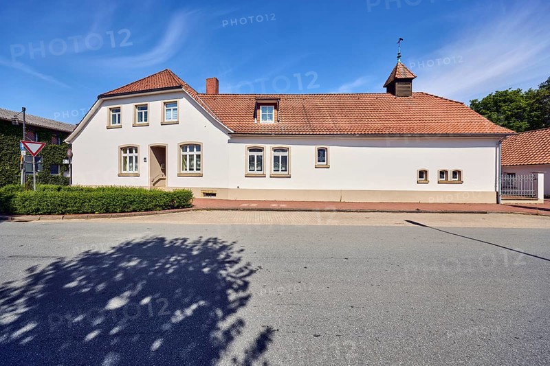 Historic residential building and commercial building, façade with windows, entrance, dormers, crested hipped roof, brick chimney, former textile shop, hedge, trees, blue sky, cirrus clouds, Campemoor Straße, Osnabrücker Straße, district of Vörden, Neuenkirchen-Vörden, district of Vechta, Lower Saxony, Germany