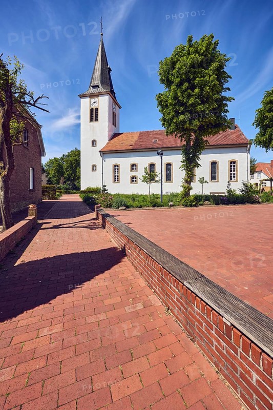Ev. Church -Luth. parish of Vörden, church tower, general architecture, paving brick walkway, trees, blue sky, cirrus clouds, Große Hinterstraße, district of Vörden, Neuenkirchen-Vörden, district of Vechta, Lower Saxony, Germany