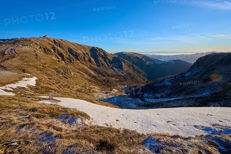 Extensive mountain landscape with snow and trail under clear sky in the morning sun, winter, Route de Cretes, Hohneck, La Bresse, Vosges, France