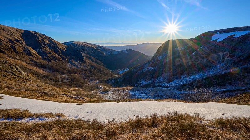 Snowy valley at sunrise with clear blue sky and bright sunbeams, winter, Route de Cretes, Hohneck, La Bresse, Vosges, France
