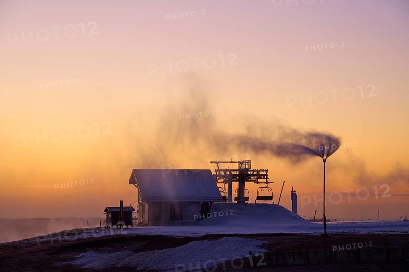 Snow cannons produce fog in orange sunset, winter, Route de Cretes, Hohneck, La Bresse, Vosges, France