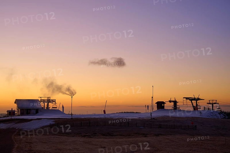 Snow cannons and silhouettes of buildings in evening light against a purple sky, winter, Route de Cretes, Hohneck, La Bresse, Vosges, France