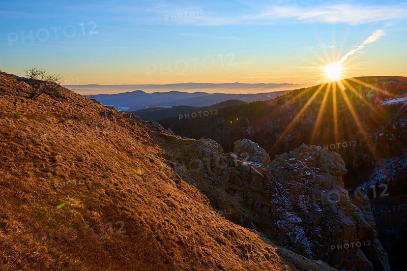 View over a sunlit rock edge in a vast mountain landscape, looking towards the Rhine Valley, viewpoint, La gorge de Pierrel, Martinswand, Frankental, Vosges, France