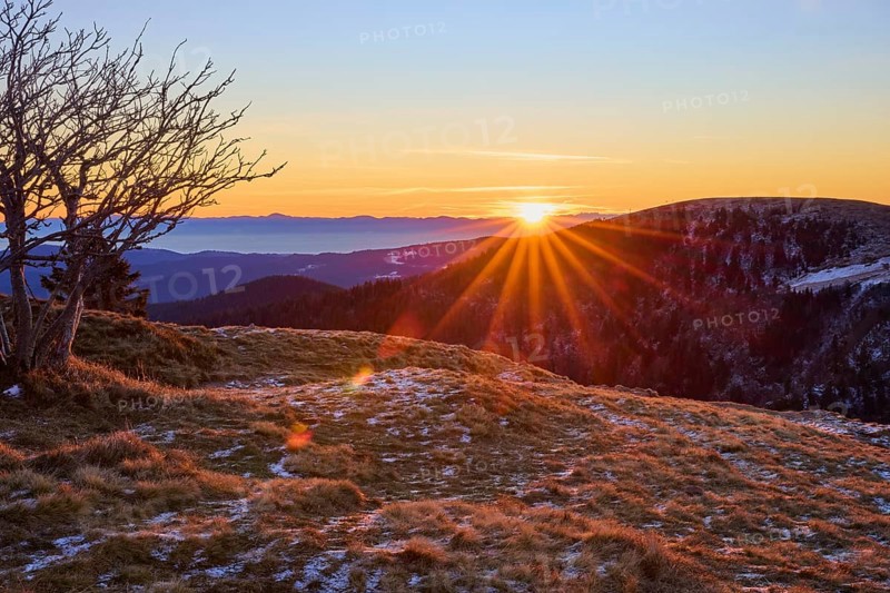 An extensive valley illuminated by the rising sun, with snow-covered slopes and golden rays, looking towards the Rhine Valley, viewpoint, La gorge de Pierrel, Martinswand, Frankental, Vosges, France