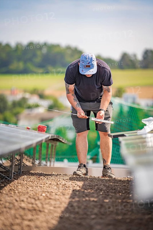 A man on a construction site measuring for the installation of solar systems, new Park and Ride parking garage Calw Heumaden on the new Hermann Hessebahn, Calw, Germany