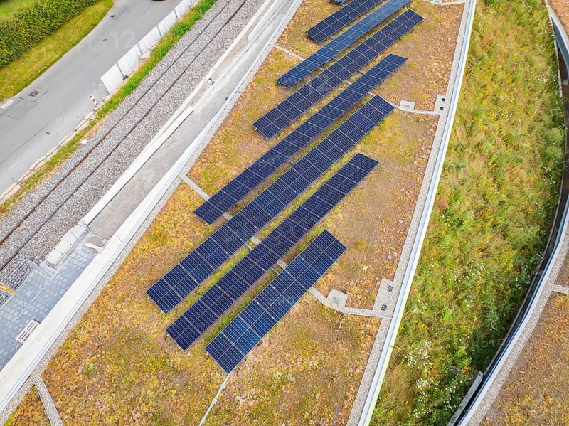 Close-up of solar panels on a green hill in urban surroundings, new park and ride car park Calw Heumaden on the new Hermann Hessebahn, Calw, Germany