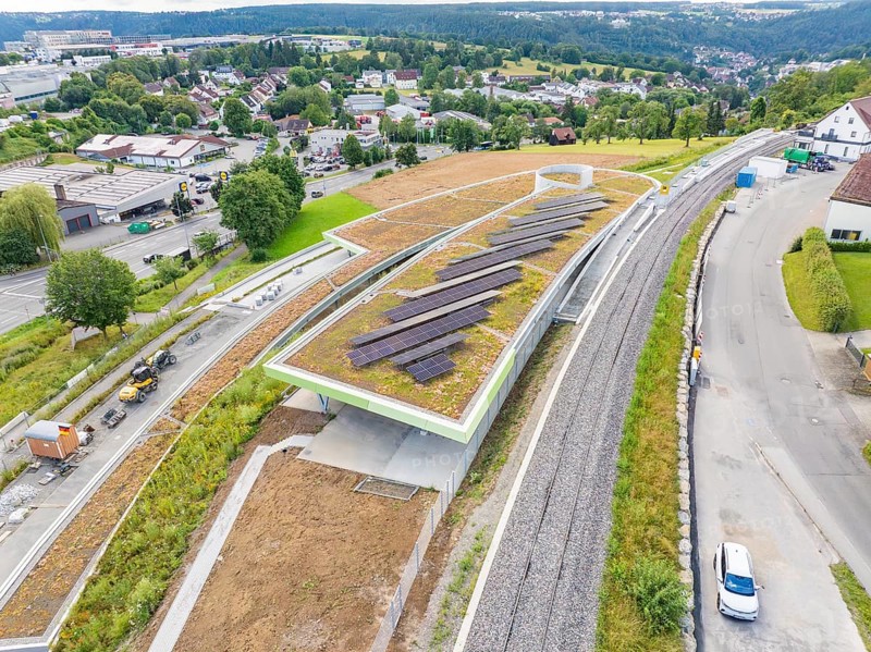Aerial view of solar systems on a roof next to traffic routes and green spaces, new park and ride parking garage Calw Heumaden on the new Hermann Hessebahn, Calw, Germany