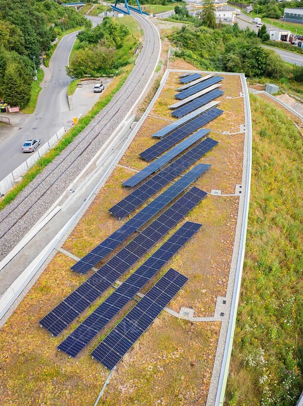 Distribution of solar modules on roof near railway tracks in urban surroundings, new Park and Ride Calw Heumaden car park on the new Hermann Hessebahn, Calw, Germany