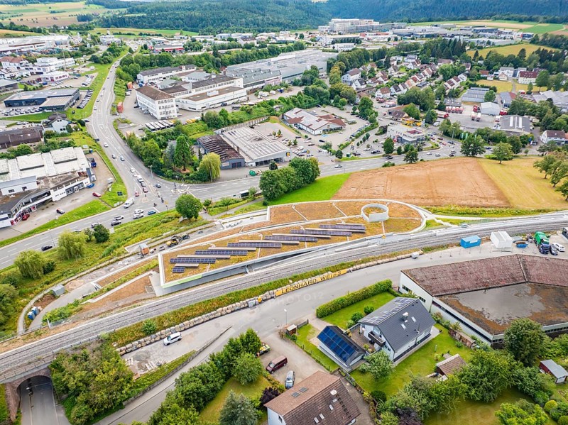 City panorama with solar systems on a hill in the middle of industrial buildings, new park and ride parking garage Calw Heumaden on the new Hermann Hessebahn, Calw, Germany