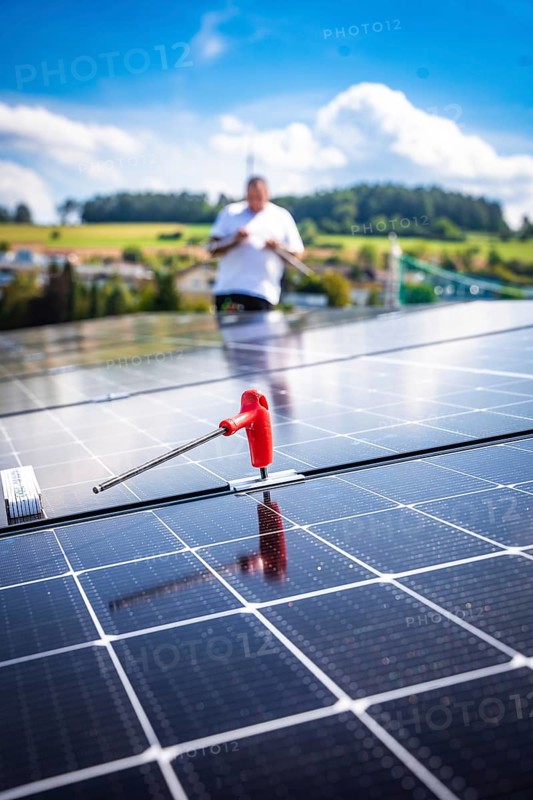 Close-up of a solar module with a working person in a rural area, new Park and Ride parking garage Calw Heumaden on the new Hermann Hessebahn, Calw, Germany