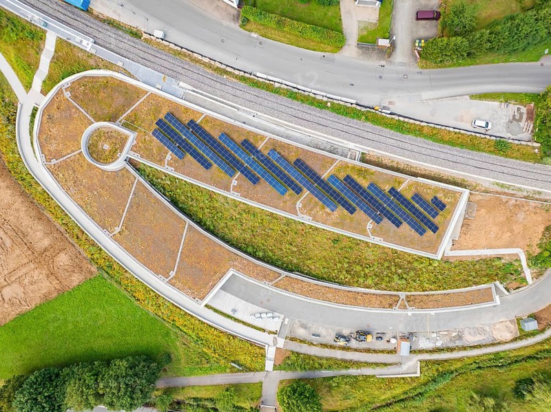 Aerial view of a solar system on an architecturally designed building in rural surroundings, new park and ride parking garage Calw Heumaden on the new Hermann Hessebahn, Calw, Germany