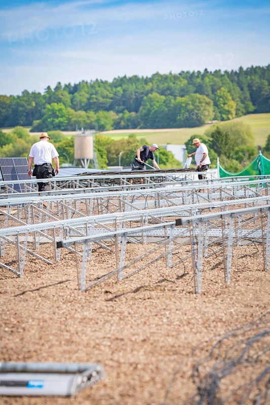 Several workers install solar panels on large racks in a scenic area, new Park and Ride Calw Heumaden car park on the new Hermann Hessebahn, Calw, Germany