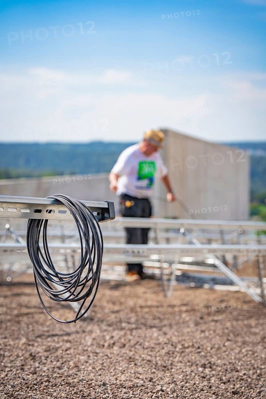 Cable against a blurred background showing workers installing a solar system, new park and ride parking garage Calw Heumaden at the new Hermann Hessebahn, Calw, Germany