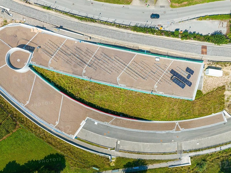 Aerial view of a green roof with solar panel and surrounding roads in urban surroundings, new park and ride parking garage Calw Heumaden on the new Hermann Hessebahn, Calw, Germany