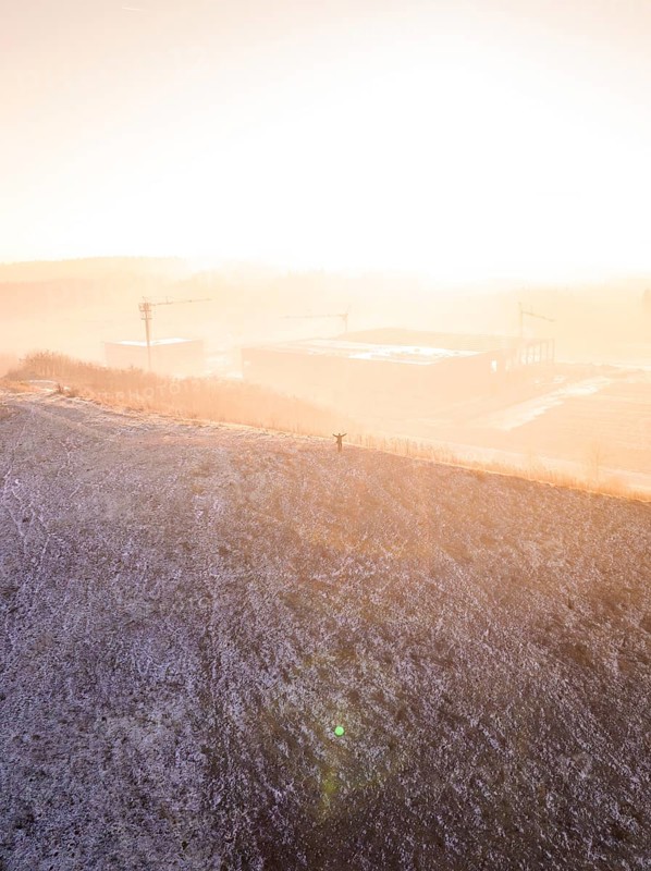 A hill in fog at sunrise, warm and cold color effects, old deposition, construction site for PV open space plant, Lindenrain, Calw, Germany