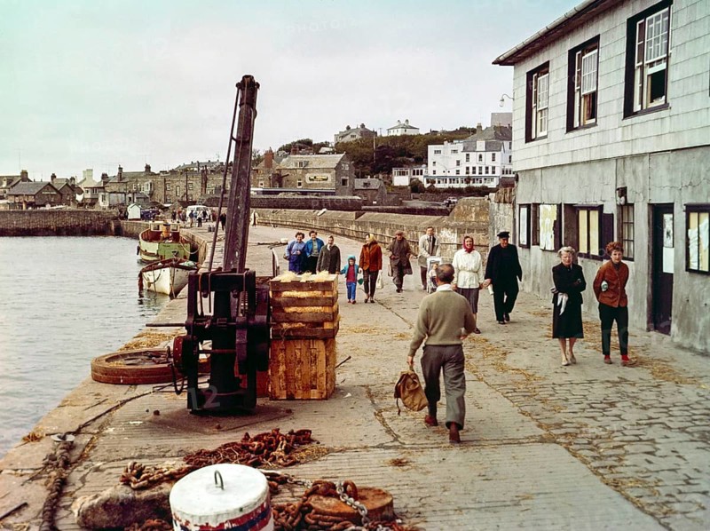 People walking along the quayside in the harbour at Hugh Town, Isles of Scilly, Cornwall, England, UK early 1960s