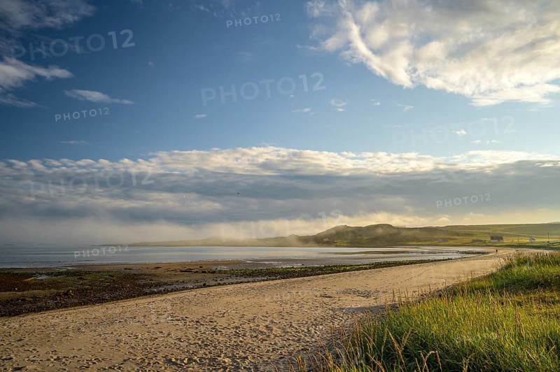 Idyllic morning atmosphere on a coast with beach, grass and wide sky on the beach of Kiberg, Troms, Norway