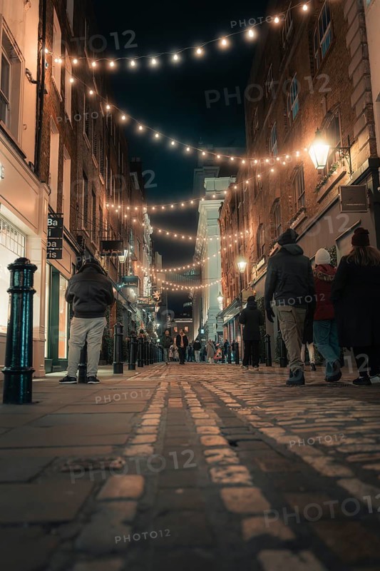 Old alley with lights and people in a warm and inviting atmosphere, London, England, United Kingdom