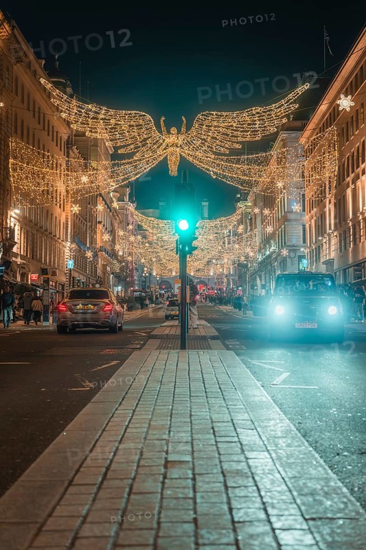 Festively illuminated street with Christmas decorations and cars at night, London, England, Great Britain