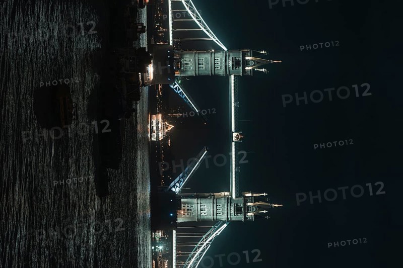 Illuminated Tower Bridge stretches across the river at night, London, England, Great Britain