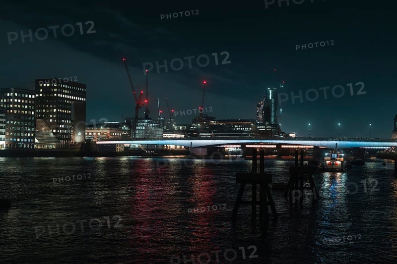River landscape with night lighting and visible cranes, London, England, Great Britain
