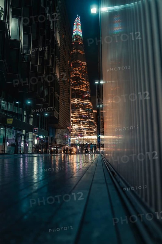 Tall illuminated skyscraper, people on the street, Shard, London, England, Great Britain
