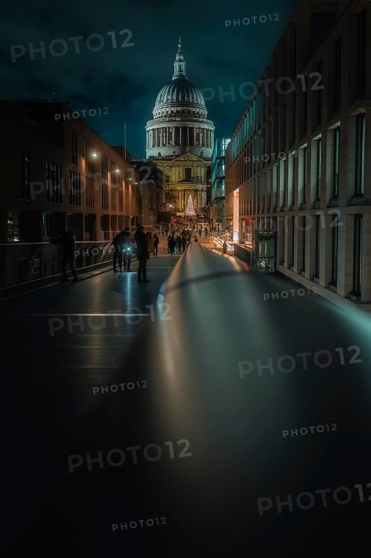 Illuminated bridge with St Paul Cathedral and city background at night, people walking, London, England, Great Britain