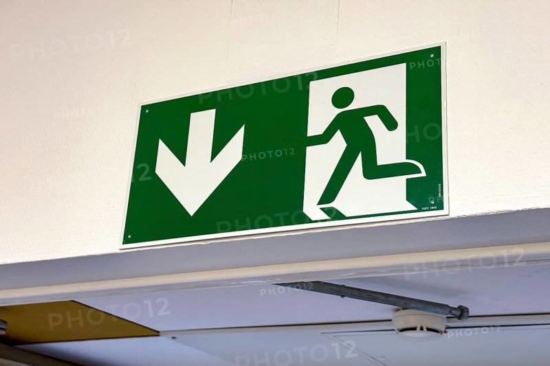 Sign with escape route emergency exit pictogram and down arrow, Germany
