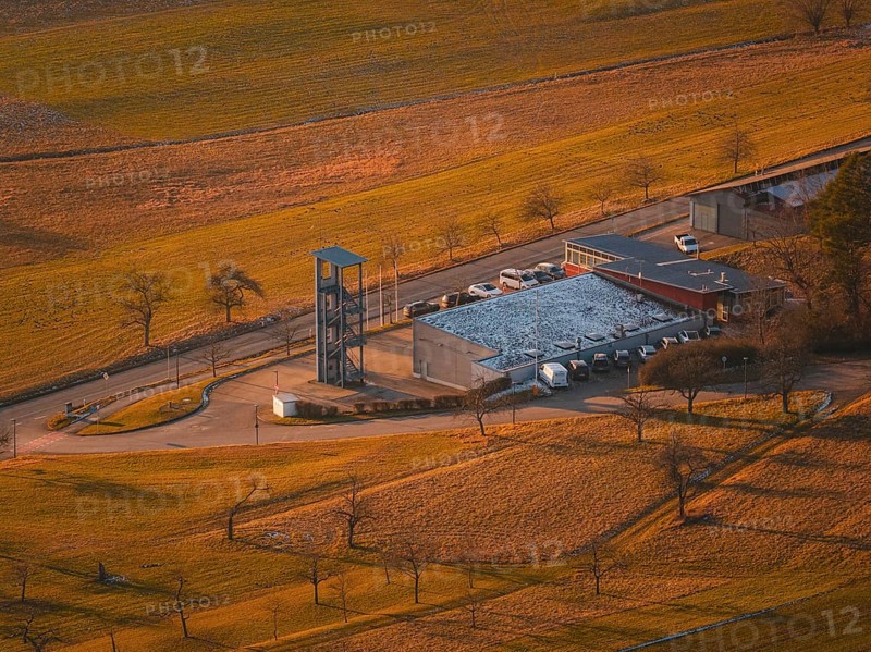 Close-up of fire station with chimney and snow-covered roof in the middle of fields, Althengstett, Calw district, Germany